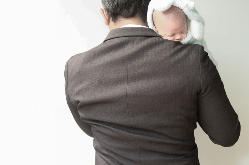 Businessman holding a baby. 